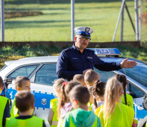 Policjant wyjaśniający dzieciom zasady ruchu drogowego